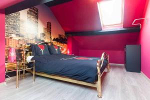 a bedroom with a bed and a pink wall at Duplex appertement met zicht Damse vaart @ Brugge in Bruges