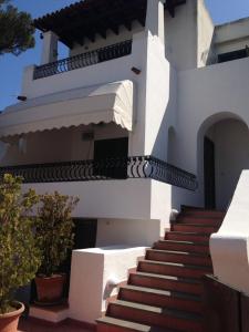 a white house with stairs in front of it at Elegante Villa al centro di Ischia Porto in Ischia