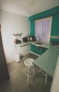 アリカンテにあるOld Town Alicanteのキッチン(緑のカウンター、テーブル、スツール付)
