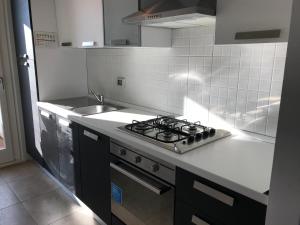 a kitchen with a stove and a sink at Appartamento Parini in Porto San Giorgio