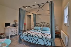 a bedroom with a metal canopy bed with blue pillows at Le Mas de Bertagne in Gémenos
