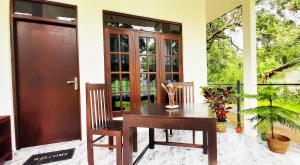 une table et des chaises en bois devant une maison dans l'établissement Dream Villa Sigiriya, à Sigirîya