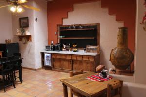 uma cozinha com uma mesa de madeira e um balcão em Adobe Rose Boutique Inn em Artesia