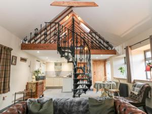a living room with a spiral staircase in a house at Stable Cottage in Berwick-Upon-Tweed