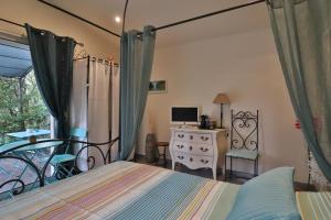 Schlafzimmer mit einem Bett, einem Schreibtisch und einem Fenster in der Unterkunft Le Mas de Bertagne in Gémenos
