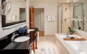 een badkamer met 2 wastafels en een douche bij River's Edge Hotel Portland, Tapestry Collection by Hilton in Portland