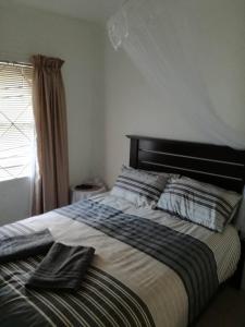 a bed with two towels on it in a bedroom at Hunters Self Catering Apartment in East London