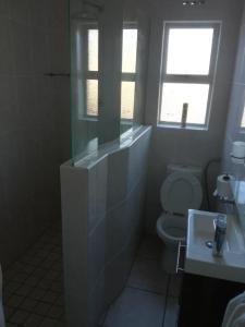 a bathroom with a toilet and a sink at Hunters Self Catering Apartment in East London