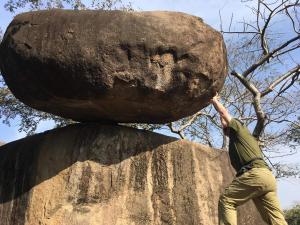a man holding a large rock on top of a rock at Pratibha Home stay in Jabalpur