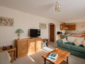 a living room with a couch and a tv at Willow Barn in Wincanton