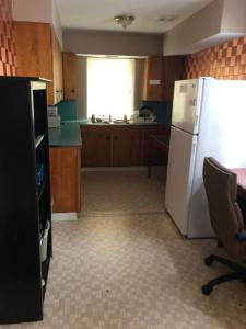 a kitchen with a white refrigerator and a window at Downtown Value Inn in Portland