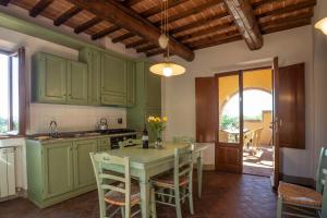 a kitchen with green cabinets and a table with chairs at Tenuta Moriano in Montespertoli