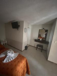 - une chambre avec un lit et une télévision dans l'établissement Hotel del Angel, à Catemaco