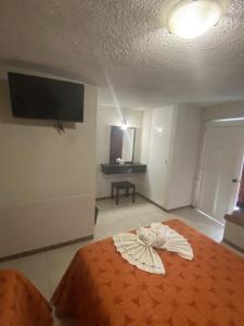 - une chambre avec un lit et une robe dans l'établissement Hotel del Angel, à Catemaco