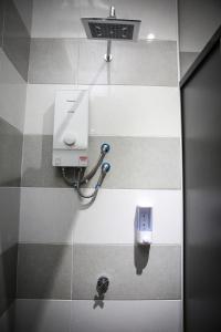 une salle de bains avec un distributeur de savon sur un mur carrelé dans l'établissement TBS Rest & Go Transit Motel, à Kuala Lumpur