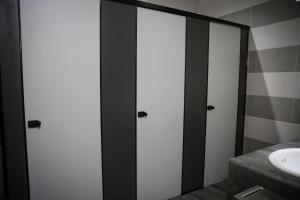 baño con 3 puertas de cristal y lavamanos en TBS Rest & Go Transit Motel, en Kuala Lumpur