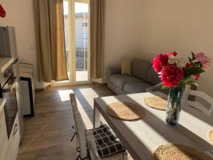 een woonkamer met een bank en een tafel met bloemen bij Il giardino dei limoni in Suvereto