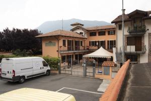 a white van parked in a parking lot in front of a building at La Locanda del Priore in Vale