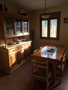uma cozinha com uma mesa de madeira e uma sala de jantar em La casa de Martina em Pedraza