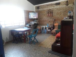 a room with a table and chairs and a bedroom at Casa Indaiá BnB - casa compartilhada in Caraguatatuba