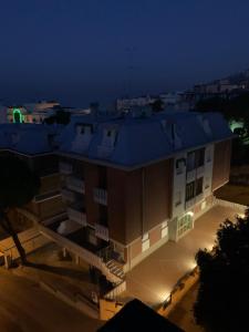 a building with a blue roof at night at Appartamenti Maria in Gabicce Mare