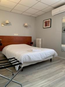 a bedroom with a bed and a chair in it at Hotel Wilson Square in Toulouse
