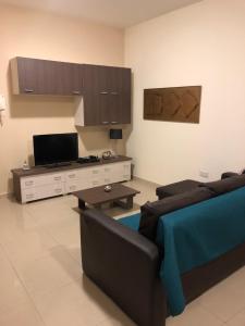 a living room with a couch and a tv at The Village Apartment 2 in Kirkop