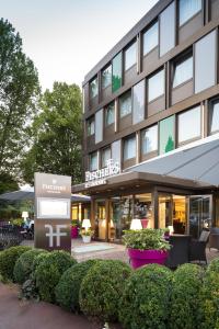 a building with a sign in front of it at FischerS - Kurparkhotel Bad Wilhelmshöhe in Kassel