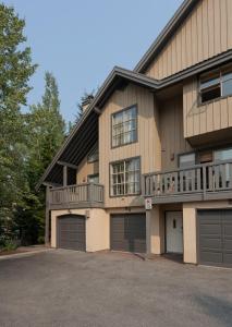 uma casa com duas portas de garagem e uma varanda em Forest Trails by Whistler Premier em Whistler