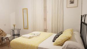- une chambre avec un lit et une couverture jaune dans l'établissement Pensión Cádiz, à Cadix