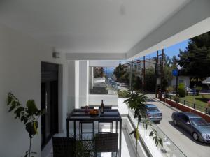 a balcony with a table and a view of a street at Atlas Relax in Kallithea Halkidikis