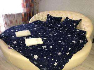 - un lit avec une couette bleue et des étoiles dans l'établissement Апартаменты Дворец Украины с круглой кроватью, à Kiev