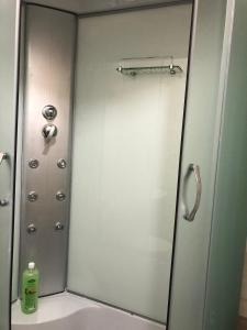 La salle de bains est pourvue d'une douche avec une porte en verre. dans l'établissement Апартаменты Дворец Украины с круглой кроватью, à Kiev