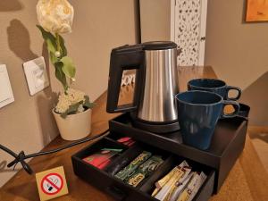 ein schwarzes Tablett mit einer Kaffeemaschine auf dem Tisch in der Unterkunft UNO Hotel Chapeau Noir in Überherrn