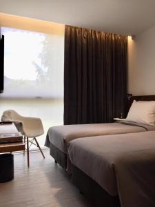 um quarto com 2 camas, uma cadeira e uma janela em CASA CHICA em El Calafate