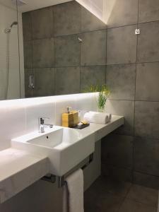 bagno con lavandino bianco e specchio di CASA CHICA a El Calafate