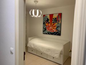 ヴィラ・レアル・デ・サント・アントニオにあるSeaside doorsのベッドルーム1室(ベッド1台付)、絵画、シャンデリアが備わります。