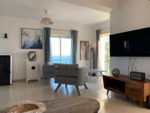 een woonkamer met een bank en een tv bij Seaside doors in Vila Real de Santo António