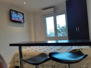 a room with a table and two blue chairs at Estudio hindu club in Don Torcuato