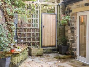 an entrance to a brick building with a wooden door at Springwood Cottage in Holmfirth