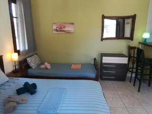 a bedroom with two beds and a desk and a mirror at George`s House in Nikiti