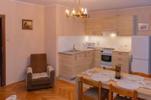 une cuisine avec une table et des chaises ainsi qu'une salle à manger dans l'établissement Apartament Brama Chlebnicka, à Gdańsk