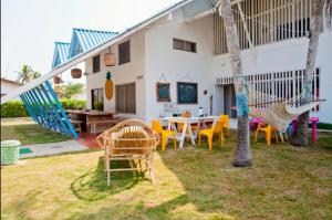 a house with a hammock and a table and chairs at Mar Amar Cabaña - Hostel in Coveñas