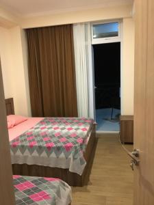 a hotel room with two beds and a window at Kvariati apartamenrs in Kvariati
