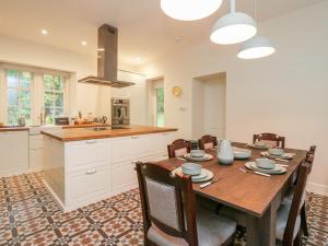a kitchen and dining room with a wooden table and chairs at East Firwood in Rothesay