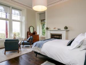 a bedroom with a large bed and a fireplace at East Firwood in Rothesay