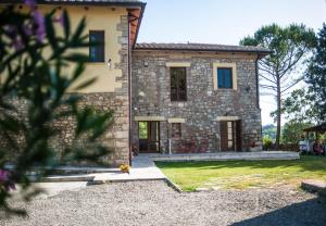 a large stone house with a yard in front of it at Agriturismo Dipinture in Asciano