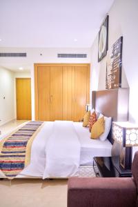 a bedroom with a bed, chair and a television at City Stay Grand Hotel Apartments - Al Barsha in Dubai
