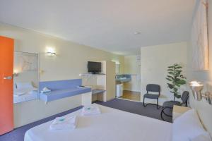 a hotel room with a bed and a television at Oscar Motel in Bundaberg