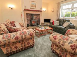 a living room with two couches and a fireplace at Wordsworth Cottage West in Morpeth
